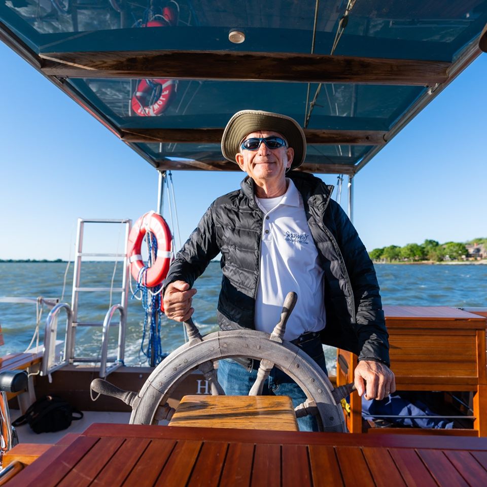 Owner Scott standing behind the wheel of his boat